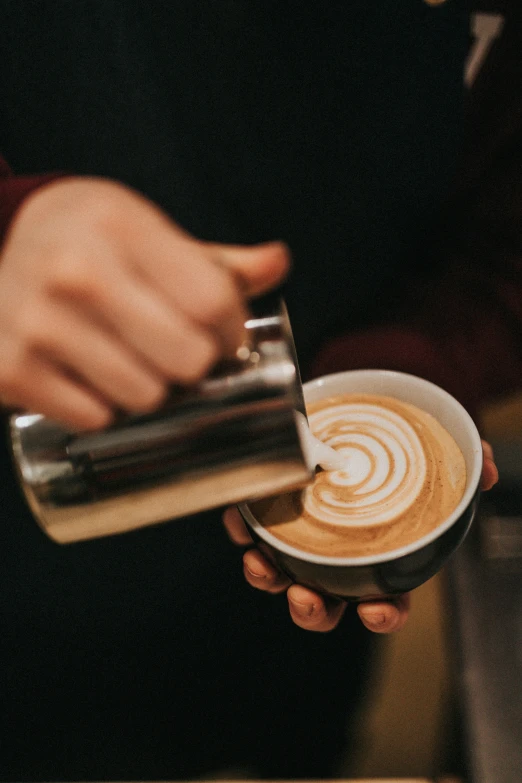 someone is pouring some coffee into a cup