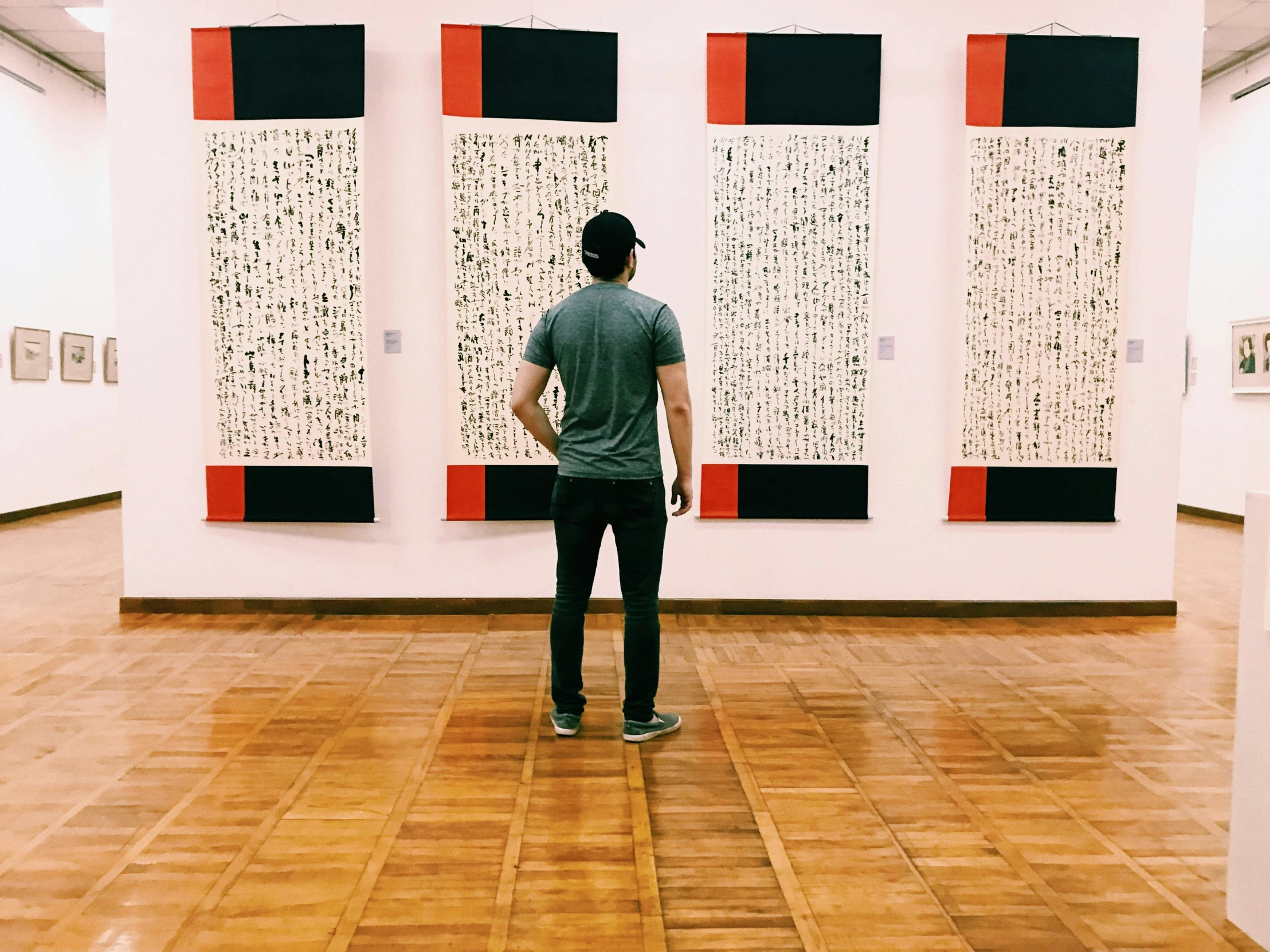 a person stands in front of some paintings