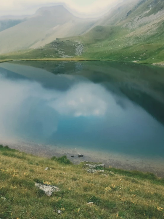 the mountain is surrounded by clouds in the distance