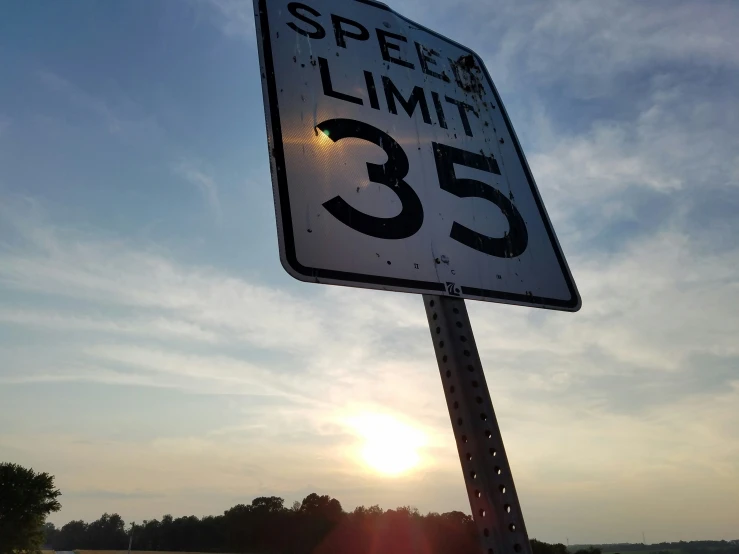 a speed limit sign is lit by the sun