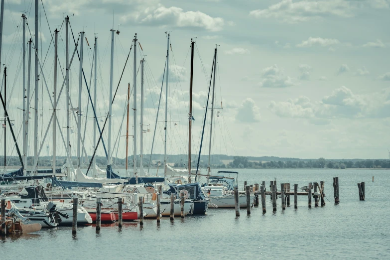 several sailboats tied up to a pier on the water