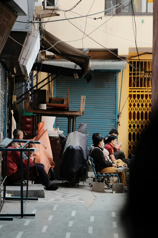 several people sitting around on chairs outside