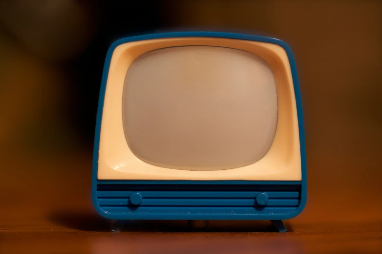 an old blue television sitting on top of a wooden table
