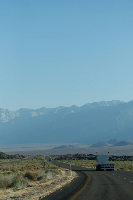 a truck is traveling down an empty road