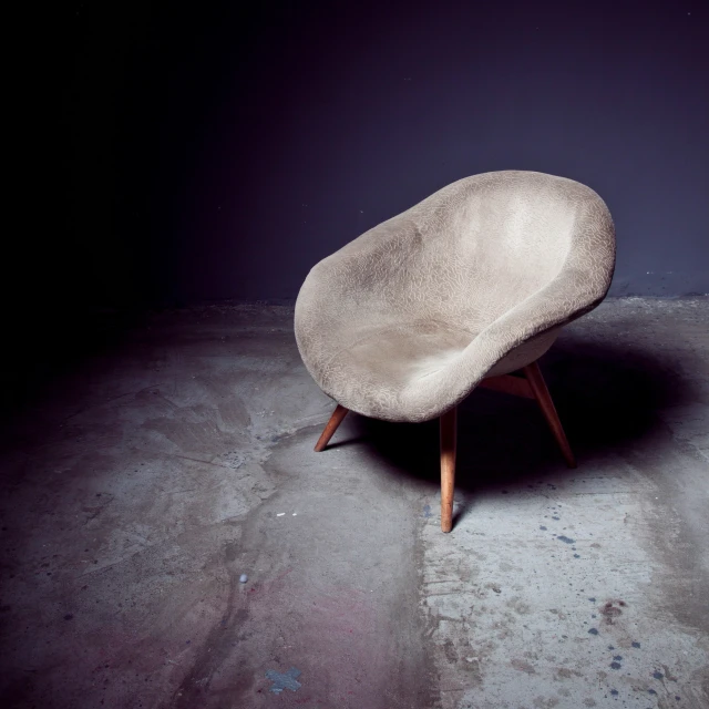 a large chair made of concrete on an empty floor