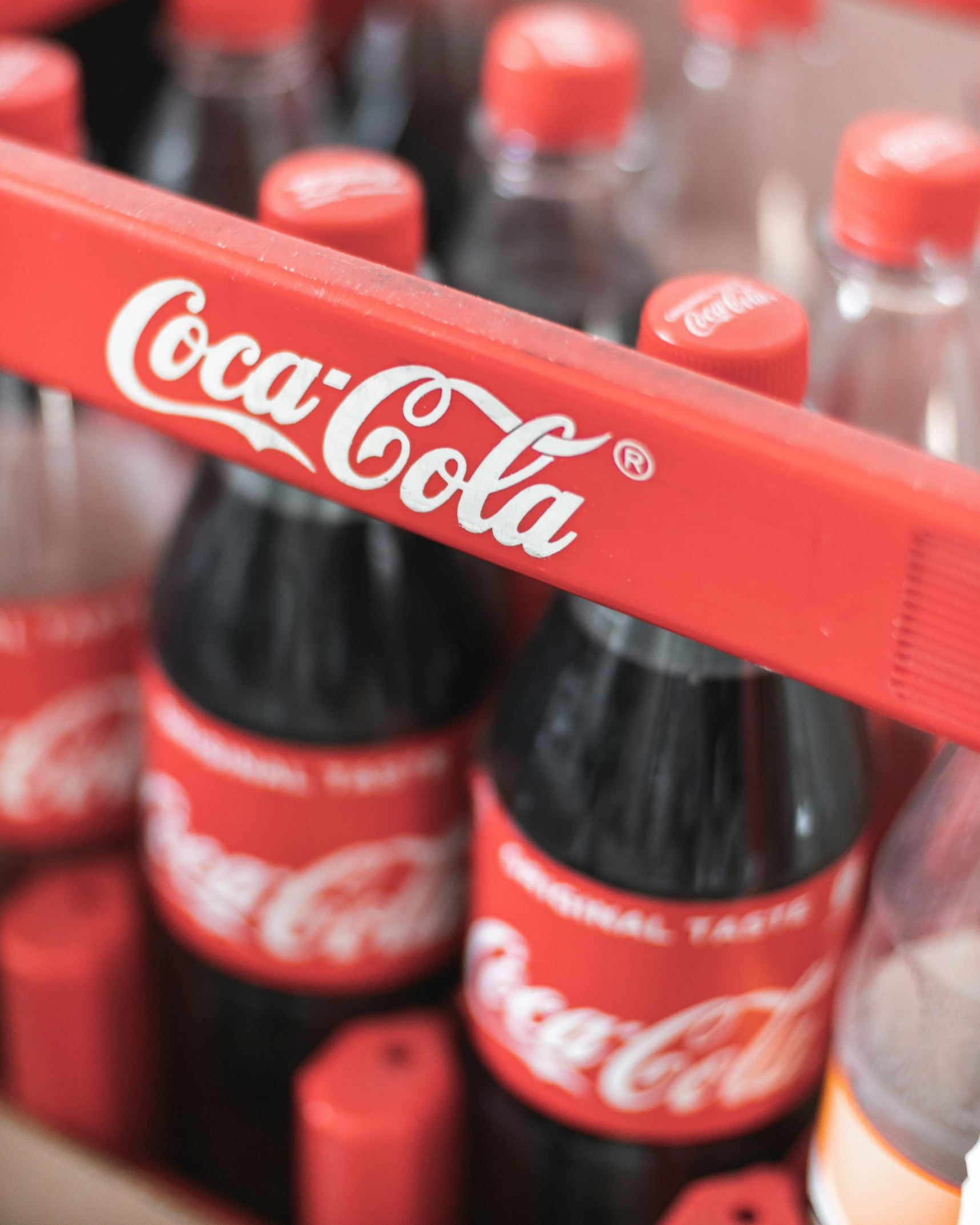 coke bottles with a plastic handle in a grocery aisle