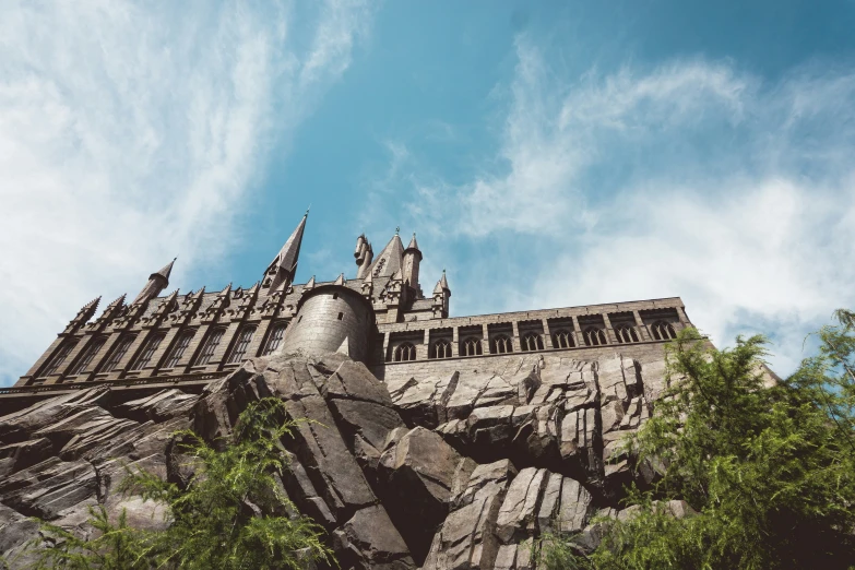 a castle stands surrounded by trees and a blue sky