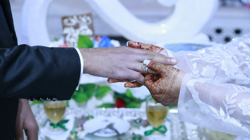 the wedding couple hold hands and prepare to put their hands on each other