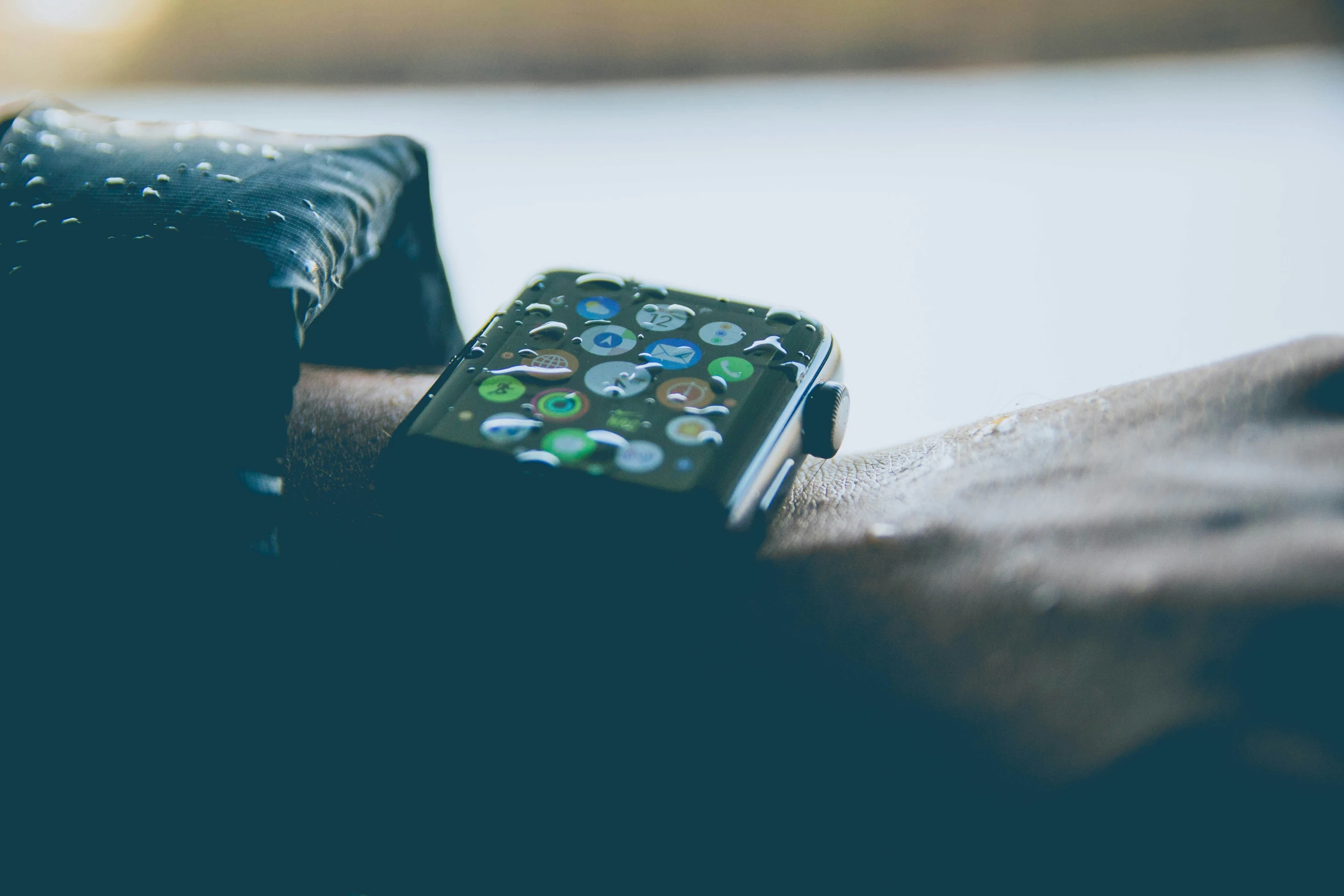 a pair of black gloved hands holding an apple watch