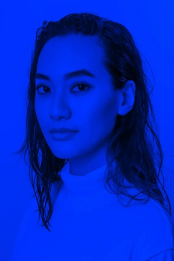 a woman posing for the camera in a blue lighting room