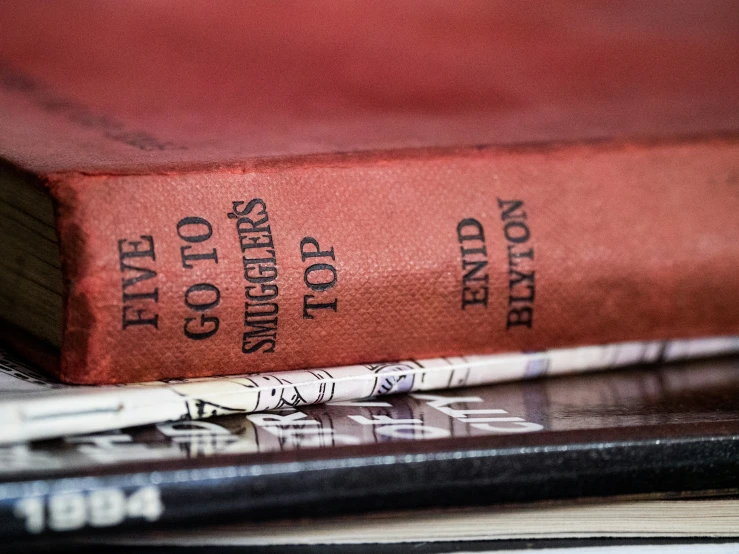 a red book is on a desk with other books