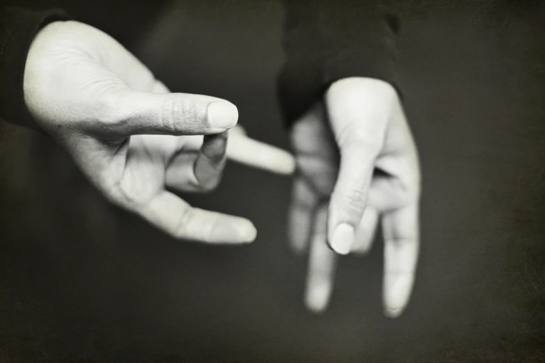 two hands touching on an outstretched hand with the fingers facing opposite directions