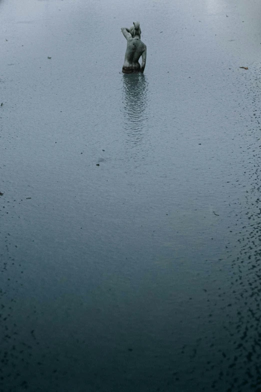 statue of man floating in water in middle of large body of water