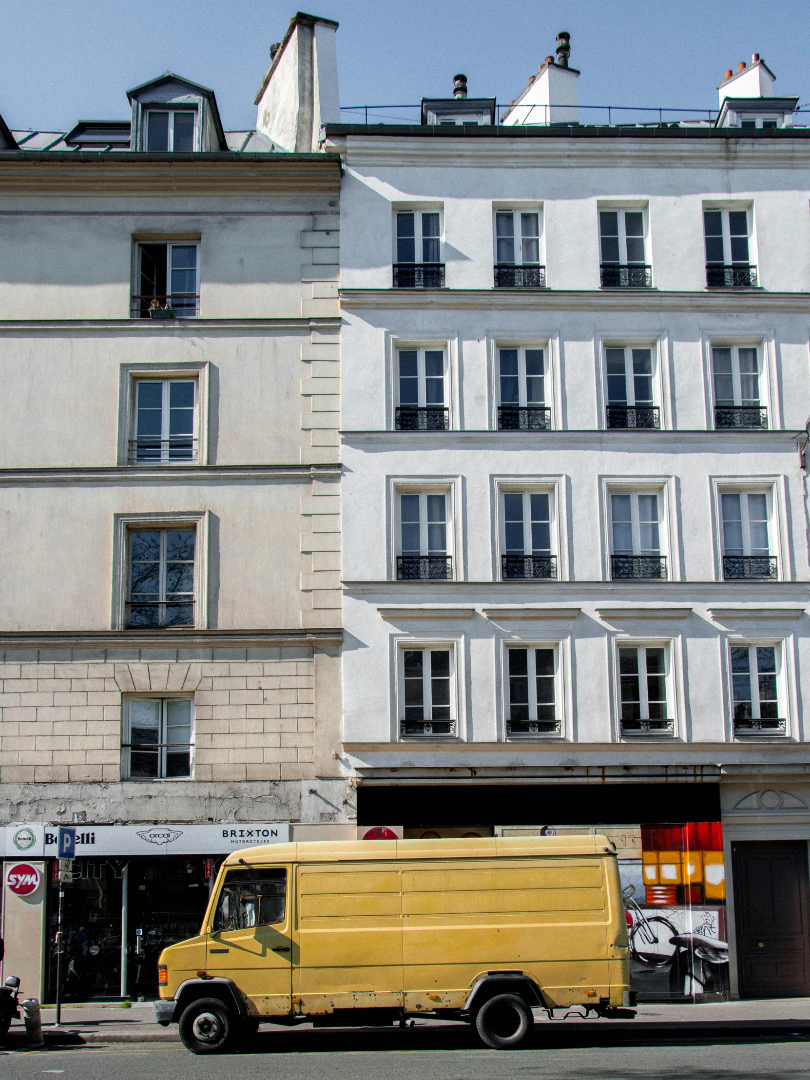 a white building with cars parked by it