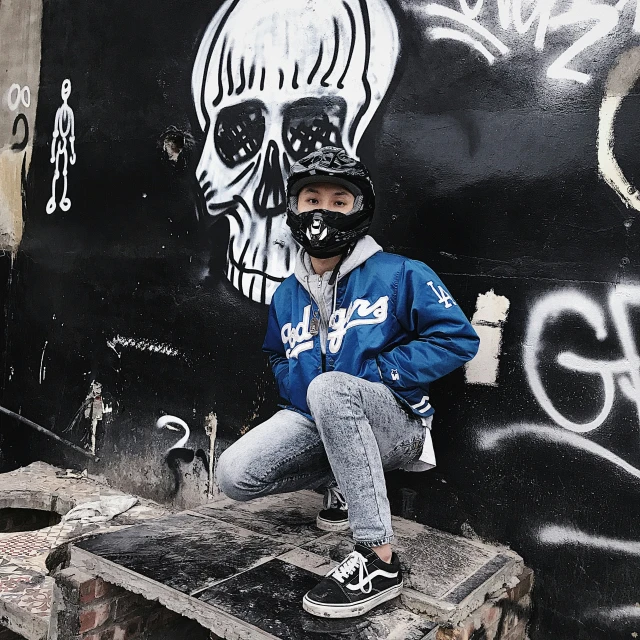 a man standing next to a wall with a skateboard