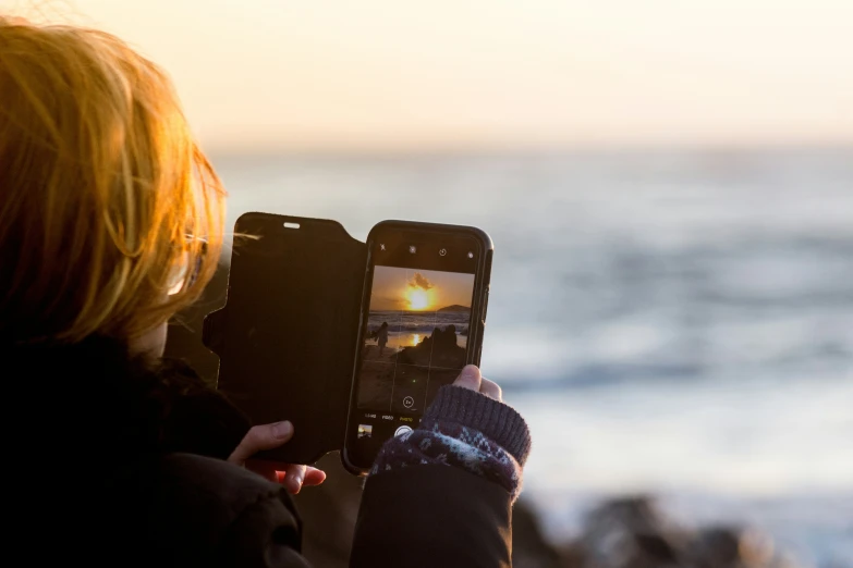 a woman using her cell phone to take a picture