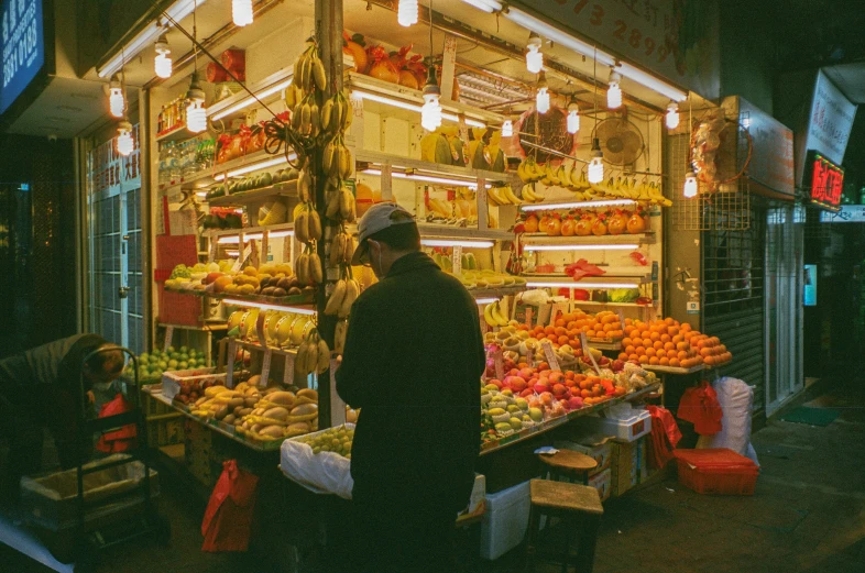 the man is standing by the large produce market