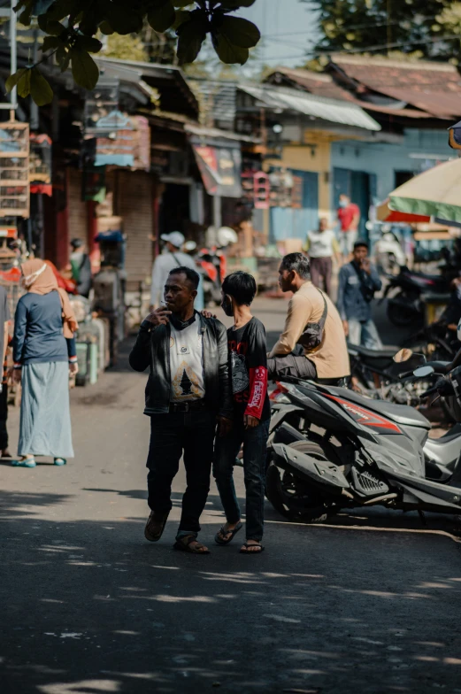 people are talking in an urban setting near a motorcycle