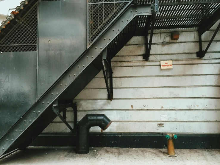 an escalator, on the side of a building with metal balconies