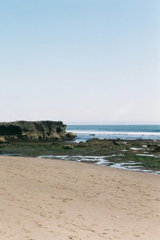 the surfboard is next to the ocean on the beach