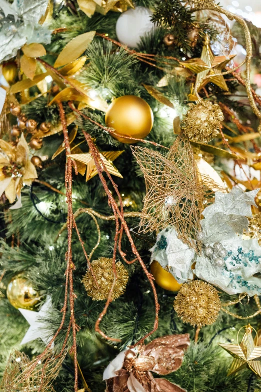 the top christmas tree is adorned with gold ornaments