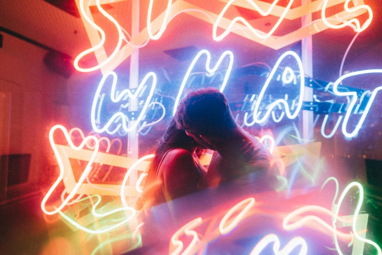 an image of a person that is standing in front of a neon sign