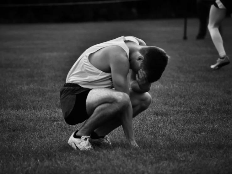 a person kneeling in the grass and touching his hand