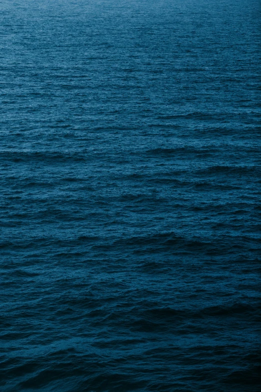 a lone boat is sitting at the edge of the ocean