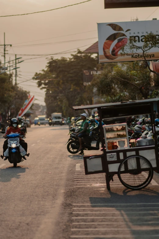 a man riding a motorcycle down a street next to a sidewalk