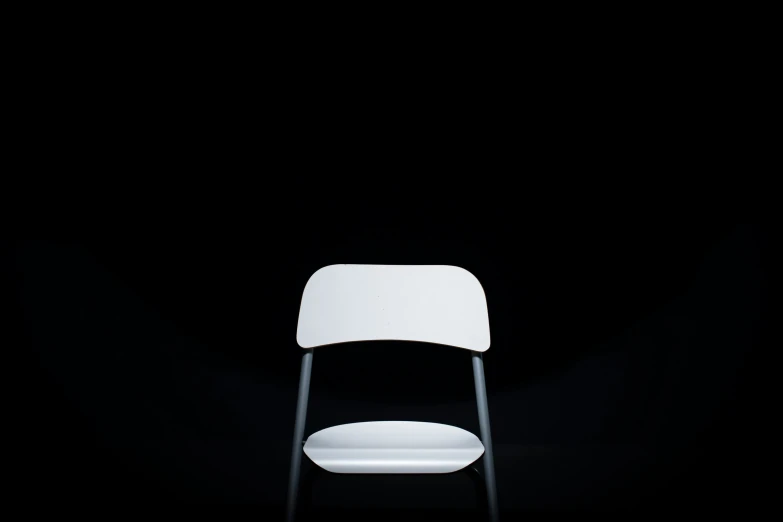 white chair against black background and spot light