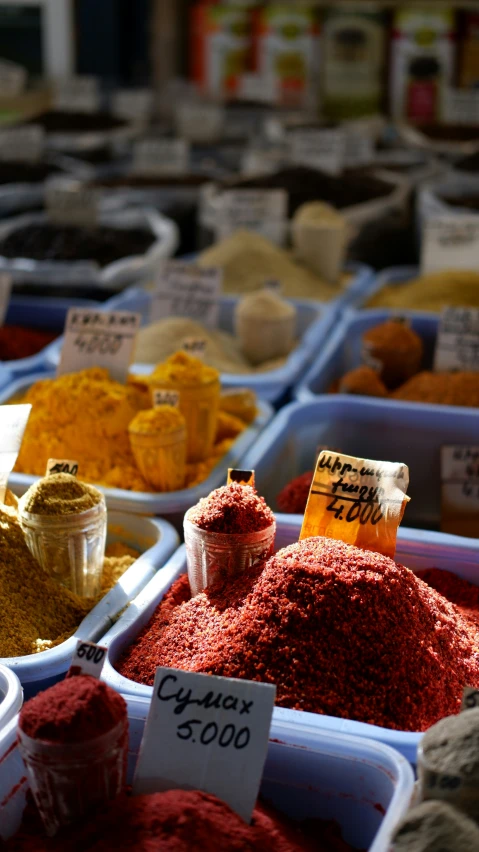 spices in containers and labels are sold at a market