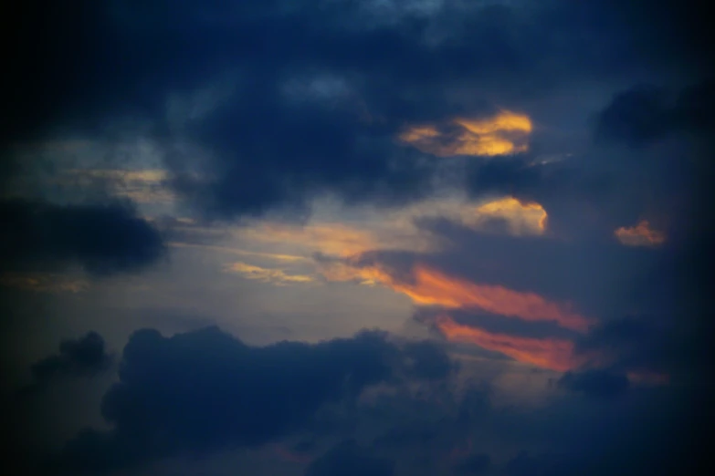 some clouds and a plane flying in the sky