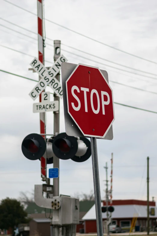 stop sign at railroad crossing with traffic signals near by