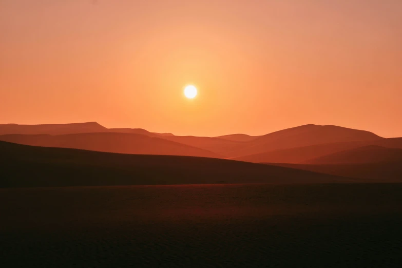 a large expanse of land is silhouetted by the sun
