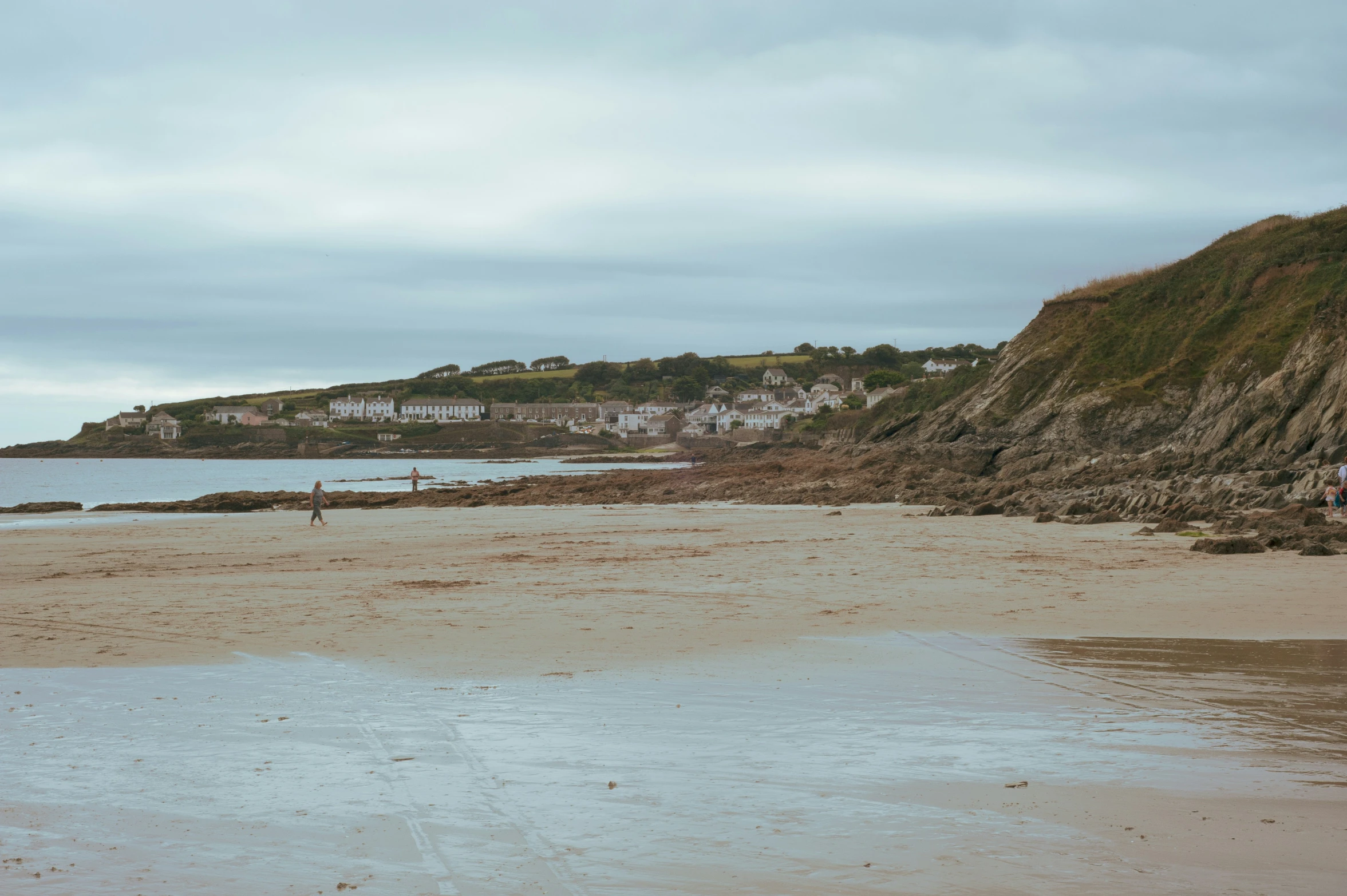 a couple of people stand on the beach