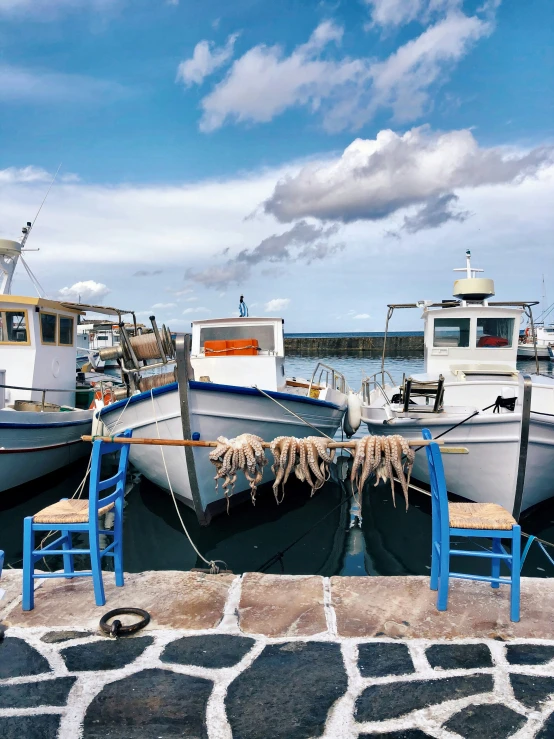 three boats on the dock with ropes around them