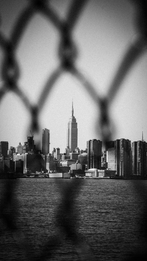 the view from behind a chain link fence in the city