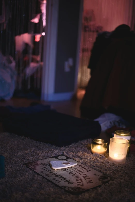 candles lit up in a dark room by an open laptop