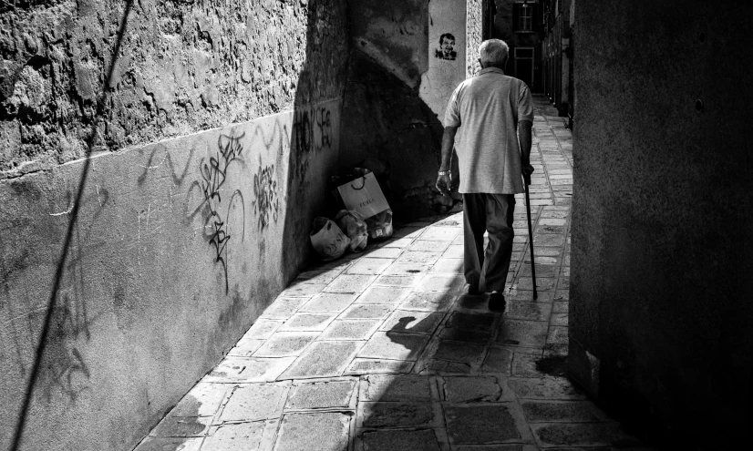 man walking through alley way next to building