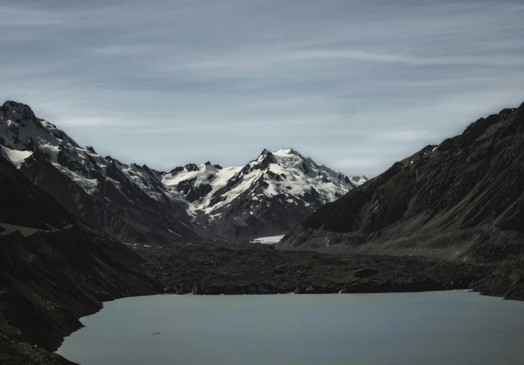 the snow capped mountains are reflected in a lake