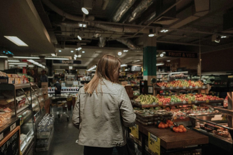 a woman in grey jacket and jeans inside of store