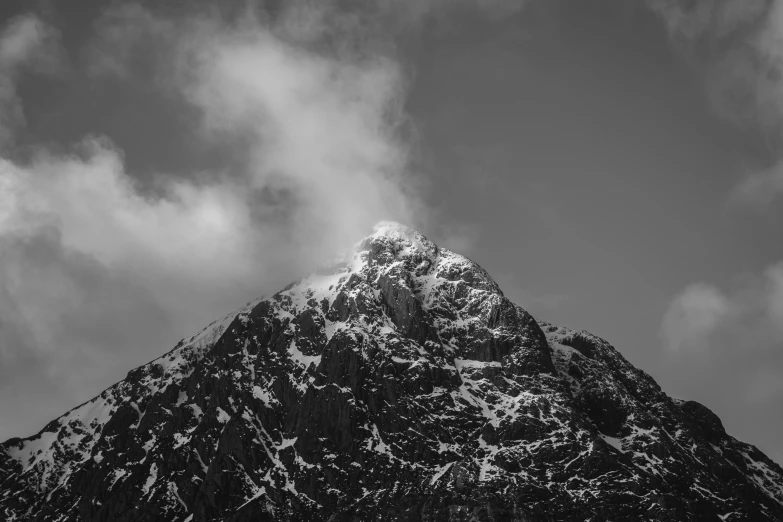 a very tall mountain with snow and clouds