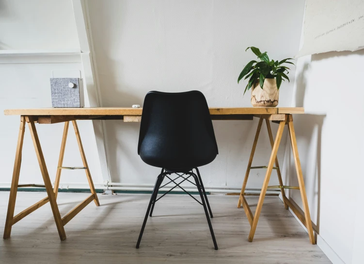 a black chair and table against a white wall