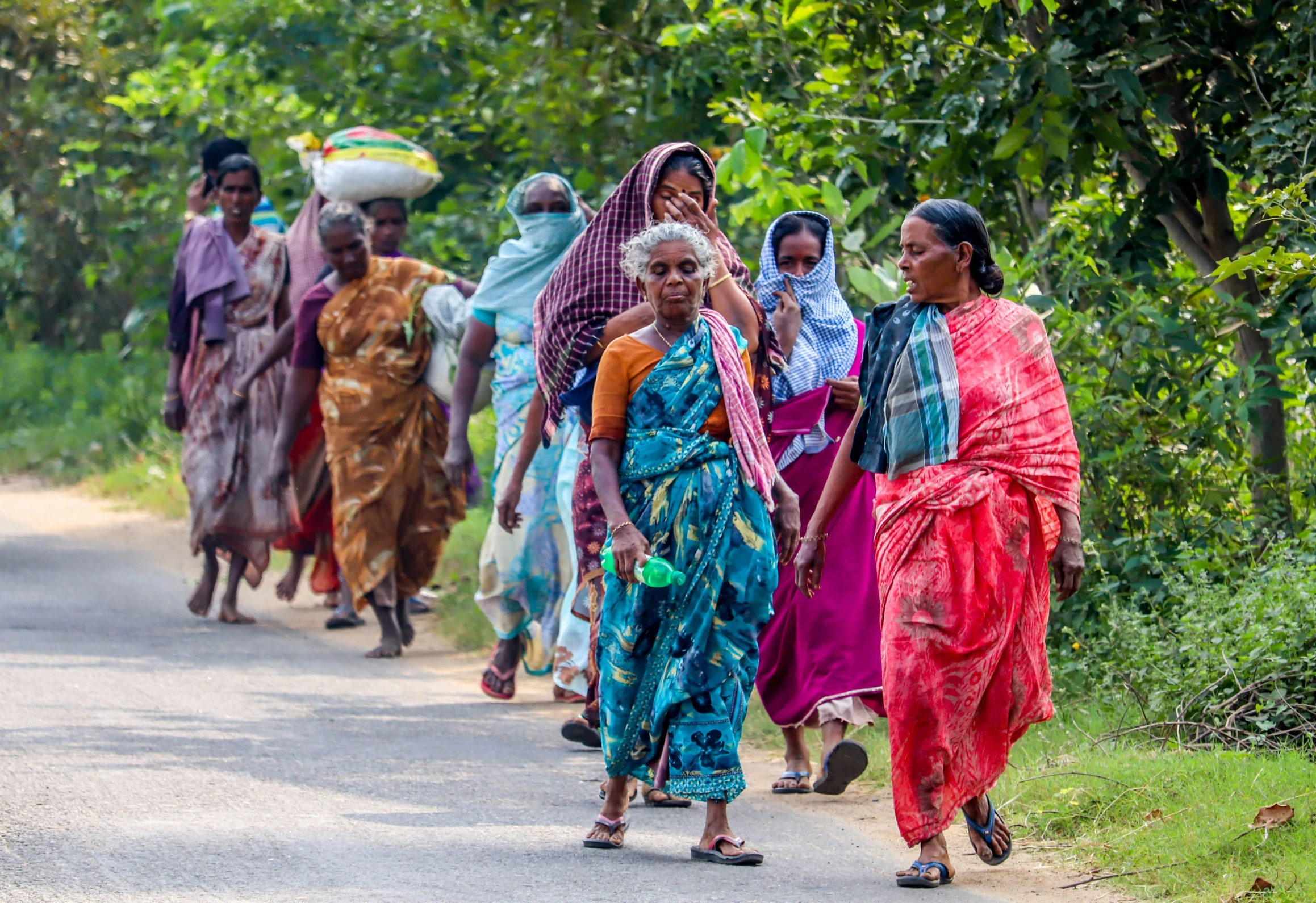 a group of women walking down a road