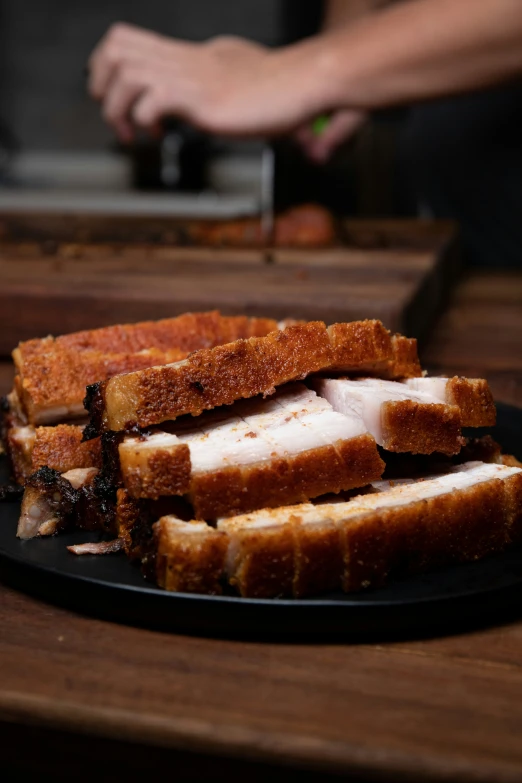 sliced sandwiches sit on a black plate with cheese