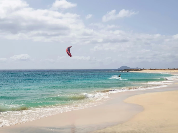 an ocean beach scene with people windsurfing