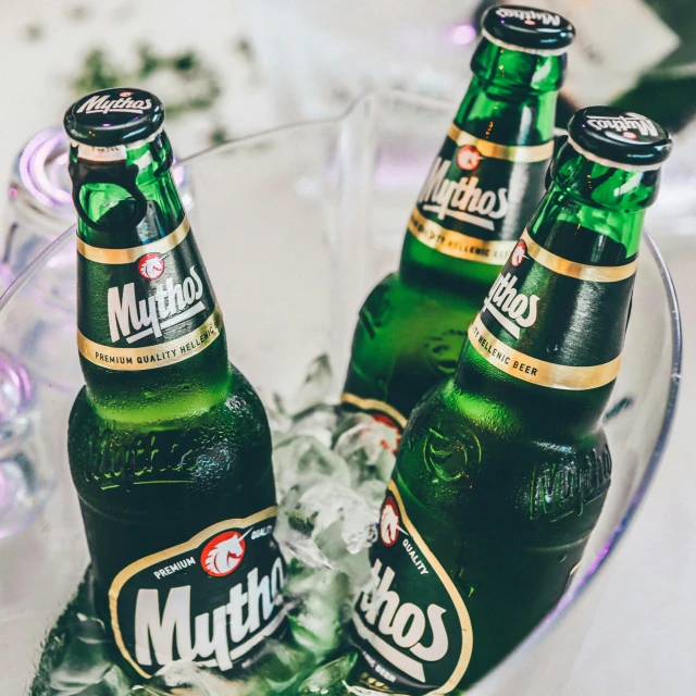 two large and two small beer bottles on ice in a glass bowl