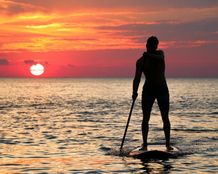 man on surfboard about to stand up in the ocean