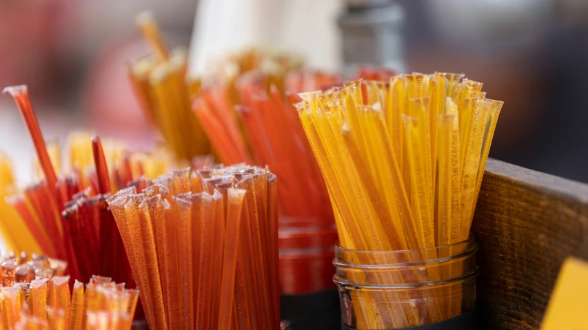 there are many orange and yellow sticks in the cup