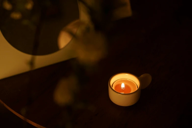 a lit candle that is on the table